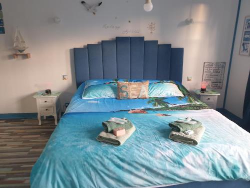 ein Schlafzimmer mit einem Bett mit zwei Handtüchern darauf in der Unterkunft Le Mouton Gras in Aumale