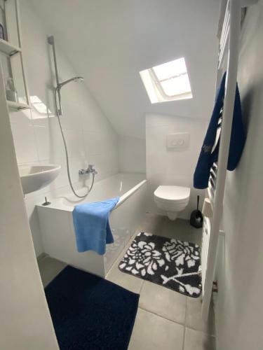 ein Bad mit einer Dusche, einem WC und einem blauen Handtuch in der Unterkunft Annie´s Appartements in Mannheim