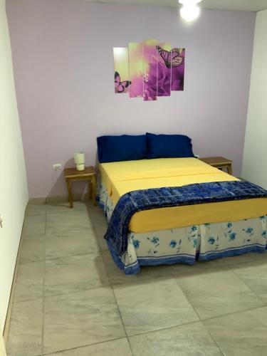 ein Schlafzimmer mit einem Bett und einem Wandgemälde in der Unterkunft LA DOLCE VITA FRANCOPHONE in Estelí