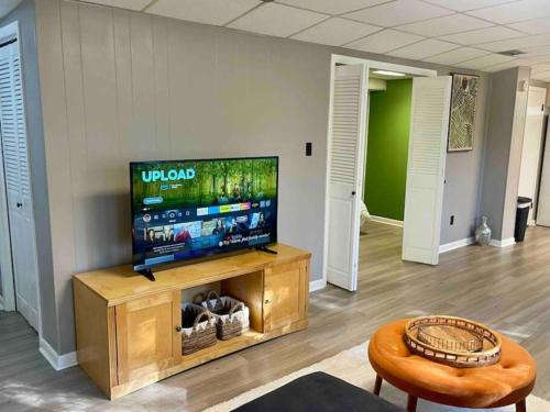 a living room with a flat screen tv on a entertainment center at Tallahassee Midtown - 2BR 2BA - 2mi FAMU FSU - 2blks TMH in Tallahassee