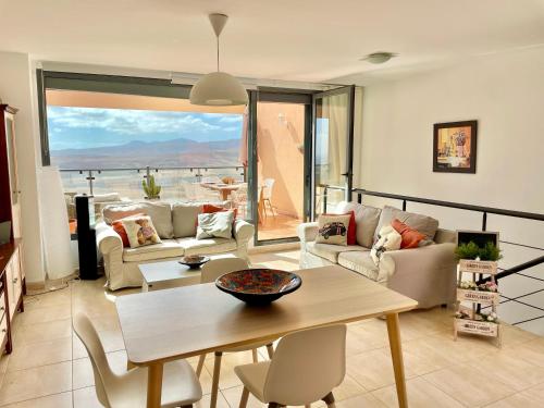 - un salon avec des canapés et une table avec vue dans l'établissement Triplex Caleta de Fuste Impresionantes vistas, à Caleta de Fuste