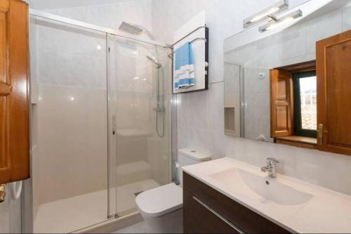 uma casa de banho com um chuveiro, um WC e um lavatório. em Casa rural de uso turístico Playa de Carnota em Canedó