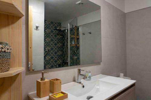 a bathroom with a white sink and a mirror at La Maison de Paofai in Papeete