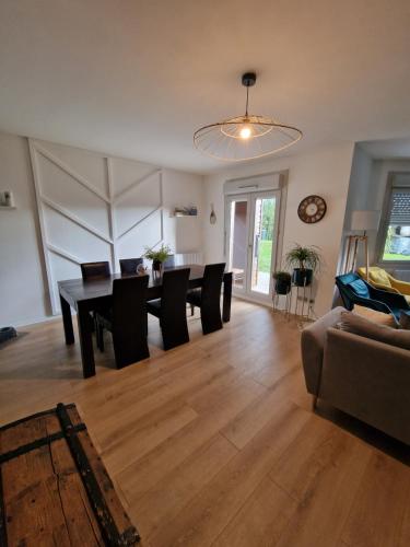 une salle à manger et un salon avec une table et des chaises dans l'établissement Maison avec Borne de recharge N1, à Rolampont
