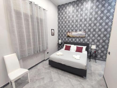 a bedroom with a bed and a white chair at Vista sull'Eremo in Naples