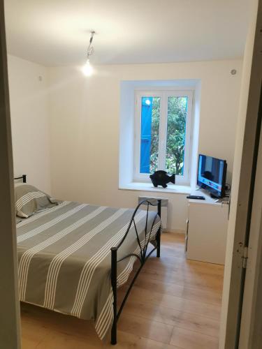 a bedroom with a bed and a cat sitting on a window at Maison de village in Ventenac-Cabardès