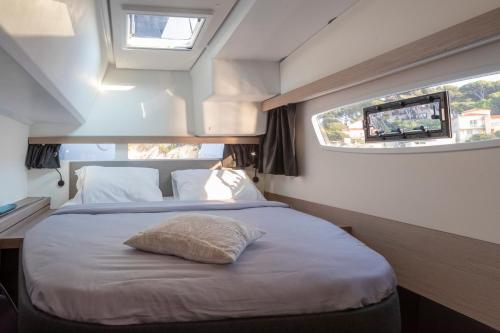 a bedroom with a bed with a window and a television at catamarano isla 40 in San Vincenzo