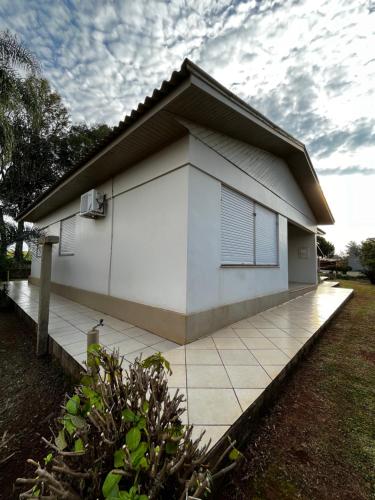 uma casa branca com uma calçada de azulejos em frente em Estadia temporada de Expodireto em Tapera