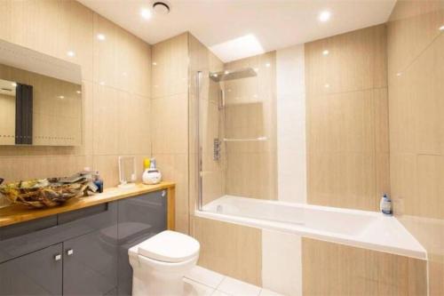 a bathroom with a tub and a toilet and a shower at Canary wharf the heart of London in London