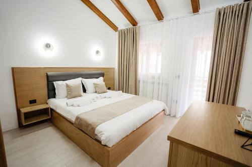 a bedroom with a large bed and a desk at Casa Mecva in Borşa