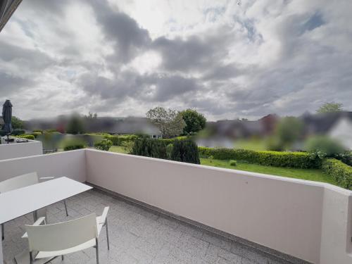 a white balcony with a table and chairs and a view at Ruhiges Juwel: frisch renoviert 100 qm in Jülich