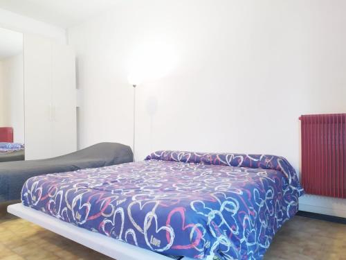 una cama con un edredón colorido en una habitación en Trento Degasperi 16, en Trento