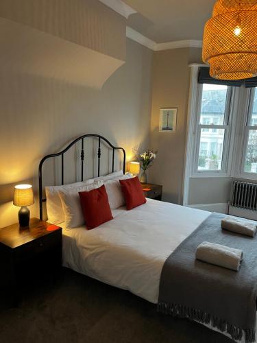 a bedroom with a large white bed with red pillows at Contemporary beach apartment in Brighton & Hove