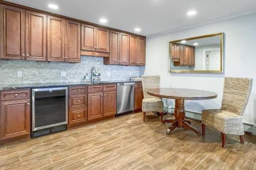 a kitchen with wooden cabinets and a table and chairs at Candlewood Lake House in Danbury