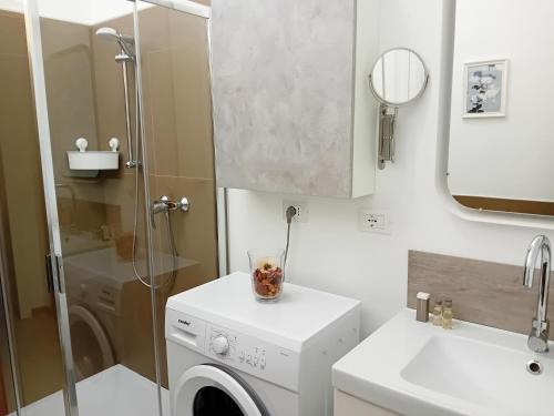 een badkamer met een wasmachine en een wastafel bij CasaRava Sul Parco in Riccione