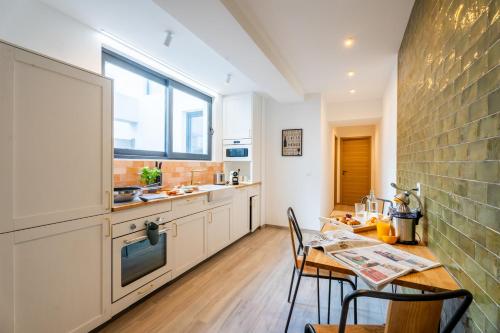 een keuken met een tafel en stoelen en een raam bij Suberbe appartement 80 m2 quartier Castellane - Le Patio - in Marseille