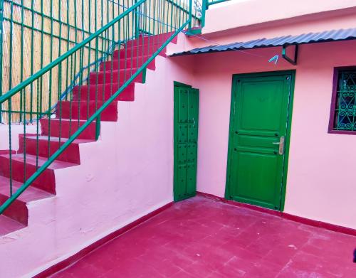 due porte verdi su un edificio rosa con scale di Fes Hostel Zaouia a Fes