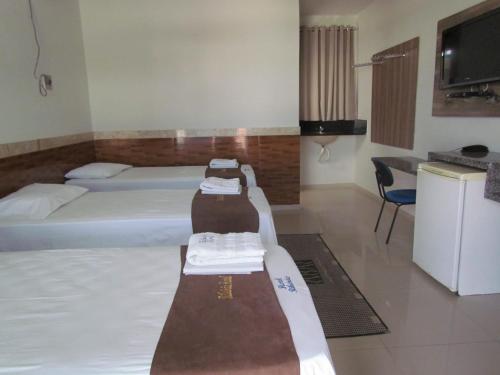 a hotel room with two beds and a tv at Ribeirao Hotel in Sousa