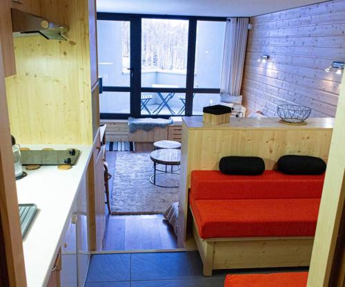 une petite chambre avec un lit rouge dans une cuisine dans l'établissement Cosy/familiale/Front de neige, à Isola 2000