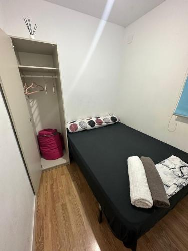 um quarto com uma cama preta e um closet em Fast Single Rooms em Madrid