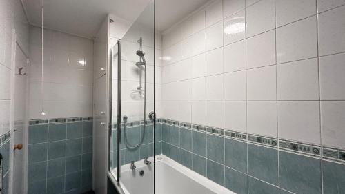 y baño con ducha y bañera. en Cozy 2 Bedroom Apartment close to Town Centre, en Woking