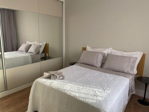 a bedroom with a large white bed with a mirror at Palace 802 in Rio de Janeiro