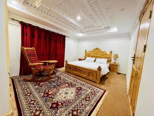 sypialnia z łóżkiem, krzesłem i dywanem w obiekcie Reelum Residency w mieście Skardu