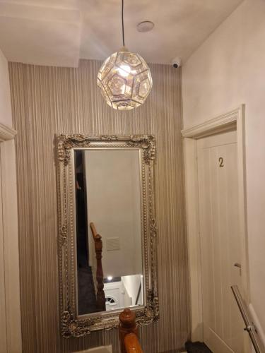 a mirror on a wall in a bathroom with a chandelier at Highfields Living - All Rooms Ensuite- Free Wifi- Free Local Parking in Sheffield