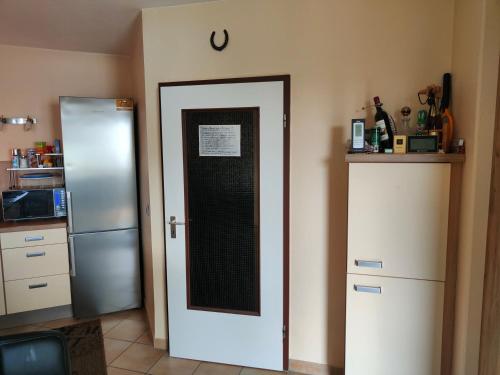 a kitchen with a refrigerator and a door at kleines Gästezimmer in Hannover