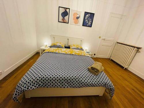 - une chambre avec un lit et une couette noire et jaune dans l'établissement Grande maison : Près de Paris/Orly, à Villeneuve-le-Roi