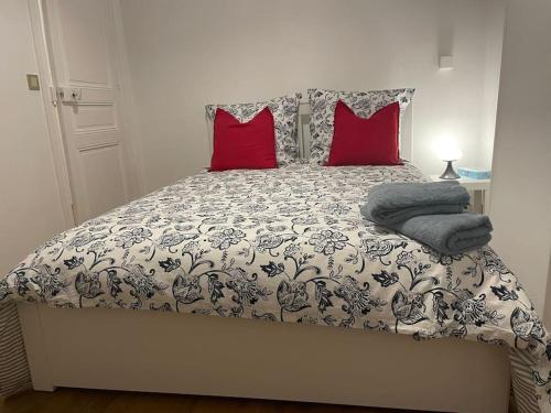 a bedroom with a bed with red pillows at Grande maison : Près de Paris/Orly in Villeneuve-le-Roi