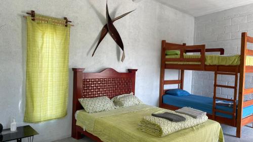 een slaapkamer met een bed en 2 stapelbedden bij Olmeca hostal Chalcatzingo 