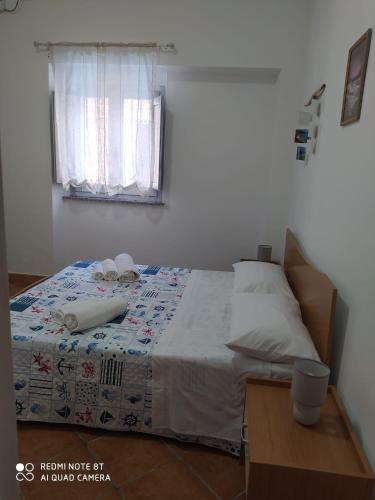 een slaapkamer met een bed en een raam bij Casa Vacanze da Merlino in Gonnesa
