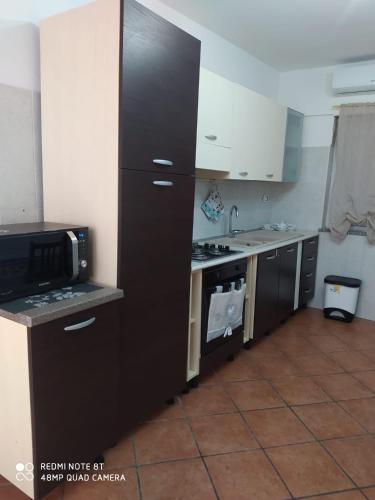 een keuken met een magnetron en een fornuis top oven bij Casa Vacanze da Merlino in Gonnesa