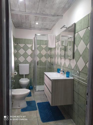 een badkamer met een toilet, een wastafel en een douche bij Casa Vacanze da Merlino in Gonnesa