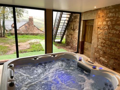 Cette chambre dispose d'une grande baignoire et d'une fenêtre. dans l'établissement Maison de famille et d'ami·e·s, à Valady