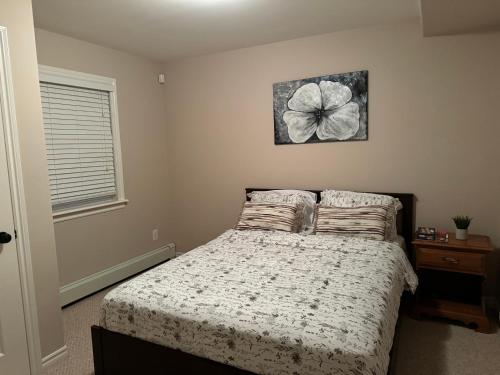 um quarto com uma cama com uma fotografia de flores na parede em Nitomik Private Suite em Halifax