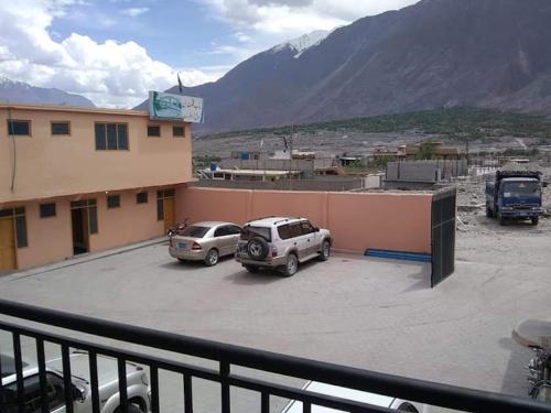 two cars parked in a parking lot next to a building at Bab e Gilgit Inn in Gilgit