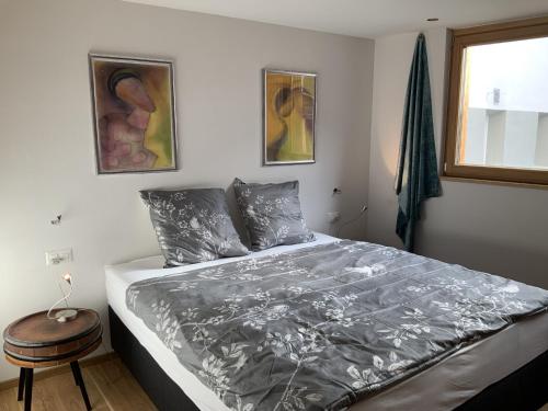 1 dormitorio con 1 cama con edredón gris en Chasa Siringia EG en Samnaun - Laret
