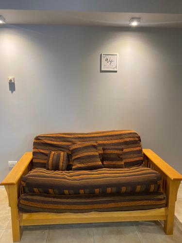 a large wooden couch sitting in a room at Departamento centro de san martin de los andes LA NONITA in San Martín de los Andes