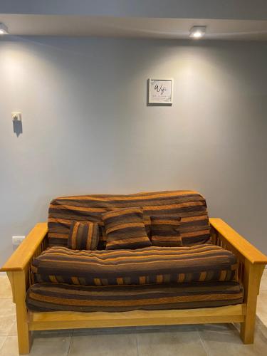 un gran sofá de madera en una habitación en Departamento centro de san martin de los andes LA NONITA en San Martín de los Andes