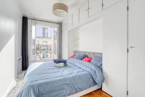 une chambre avec un lit et une fenêtre dans l'établissement Grand Appart Spacieux Rénové Paris Métro Wifi, à Paris
