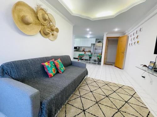 uma sala de estar com um sofá azul e uma ventoinha em FLAT 13º andar COM VISTA PARA MARagogi em São José da Coroa Grande