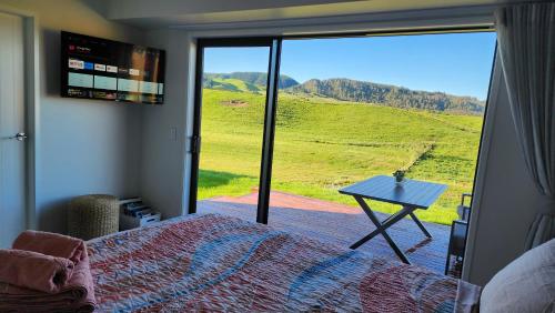 a bedroom with a bed and a table with a view at A stunning retreat in Rotorua! in Rotorua
