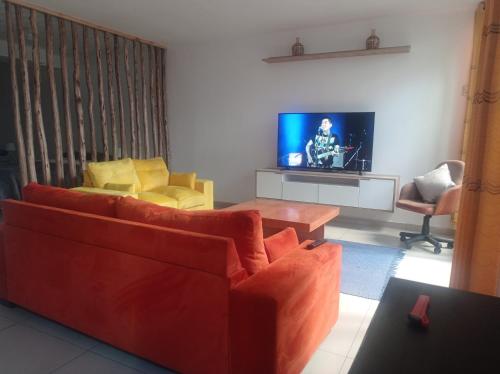 sala de estar con sofá rojo y TV en TAWA 2, en Huancayo