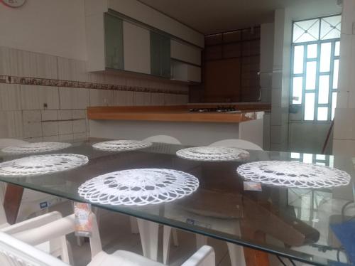 una cocina con una mesa de cristal con sillas blancas en TAWA 2, en Huancayo