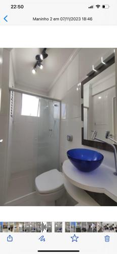 La salle de bains est pourvue d'un lavabo avec un bol bleu. dans l'établissement AP em CONDOMINIO BEIRA MAR com GARAGEM, WIFI e TV A a CABO, à Balneário Camboriú