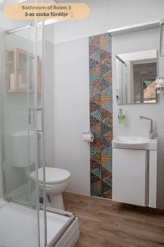 a bathroom with a toilet and a sink at Tulip Home Guest House in Vác