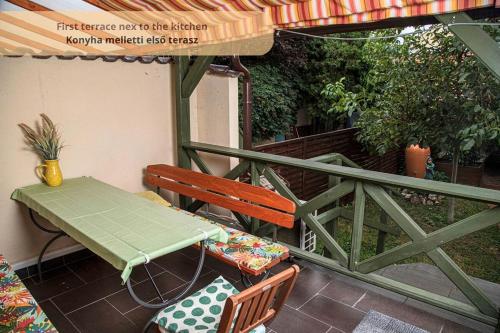 a table and chairs on a balcony with an umbrella at Tulip Home Guest House in Vác