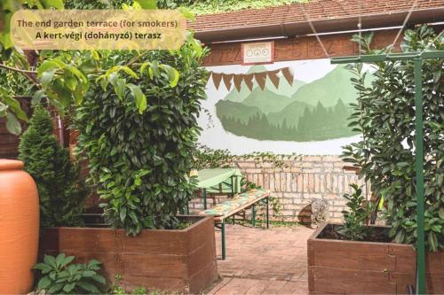a wall with a mural in a garden with a bench at Tulip Home Guest House in Vác